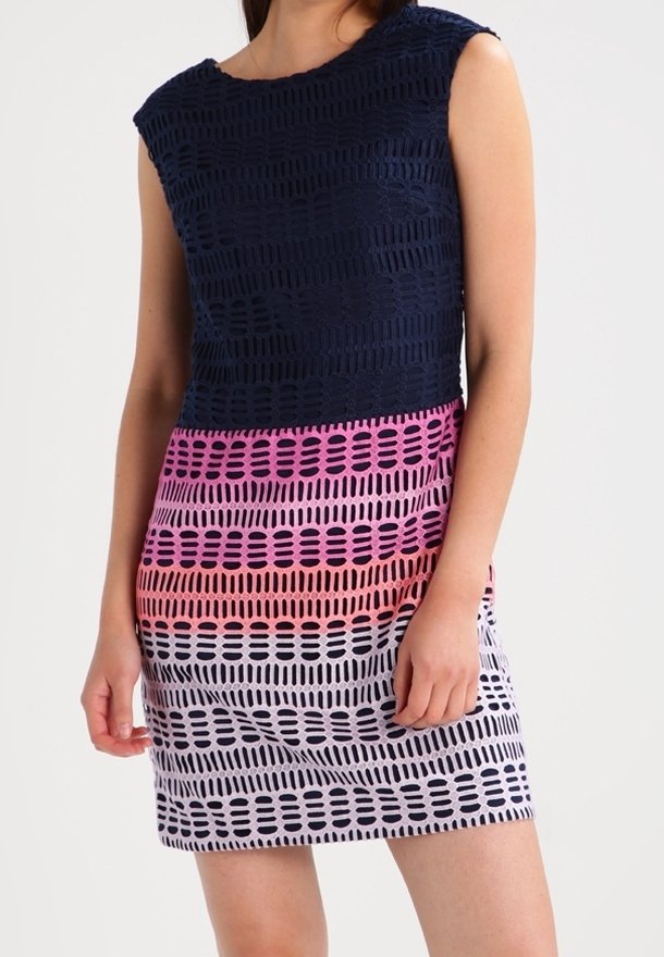 Dress with a navy upper section and a gradient of pink to white stripes below. Features textured pattern with cut-out details throughout.