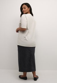 Gestreepte top met korte mouwen en ronde halslijn, in neutrale tinten, gecombineerd met een donkerdenim maxi-rok en zwarte ballerina's. Eenvoudig ontwerp.