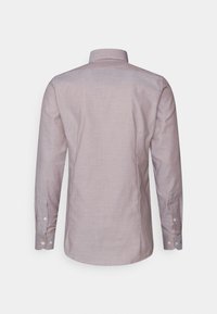 Chemise à manches longues en tissu rose clair, texture unie, avec un col classique et des poignets boutonnés, présentant un dos épuré.