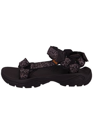Sort og grå udendørs sandal med tyk sål og justerbare mønstrede stropper, med et lille orange "Teva" logo på siden af remmen.