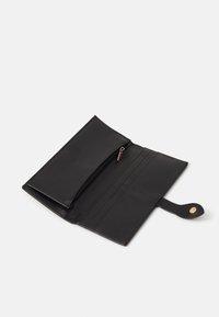 Mustapohjainen nahkalompakko, jossa on vetoketjullinen osasto, useita korttipaikkoja ja painonappi. Sileä pinta ja minimalinen muotoilu.