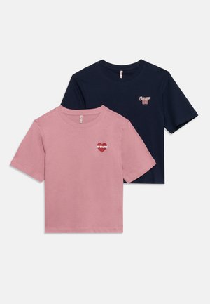 Twee T-shirts met korte mouwen en een ronde hals, één roze met een rood hart en "Je T'aime," en één marineblauw met de tekst "Chicago 95".