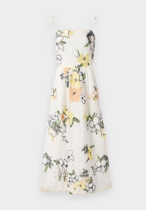 Floral-embroidered dress in white fabric, featuring yellow scalloped edges, spaghetti straps, and a fitted bodice flowing into a flared skirt.