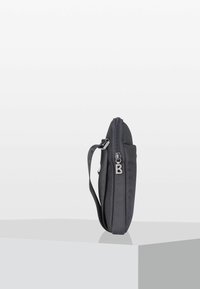Borsa in tessuto grigia con superficie tessurizzata, chiusura con zip laterale e tracolla regolabile. Presenta un dettaglio con zip a forma di "B". Forma rettangolare slim.