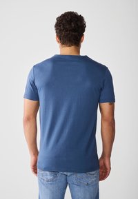 T-shirt a maniche corte blu navy con colletto a girocollo, tessuto morbido e vestibilità rilassata. Presenta una sottile texture sulla superficie.