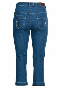Mörkblå denim capri jeans med en figurnära design, försedda med två bakfickor som pryds av blomsterbroderi och en brun läderlapp vid midjan.