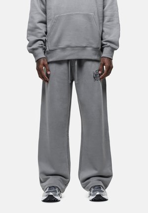 Gray sweatshirt and matching pants made from soft fabric, featuring a front pocket, drawstring waist, and subtle logo detail on pants.
