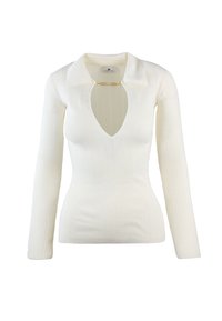 Maglietta bianca a maniche lunghe con collo a V profondo e colletto, con un dettaglio in metallo dorato all'abbottonatura. Tessuto liscio e aderente.