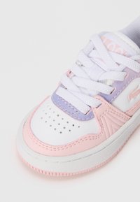 Baskets blanches avec des accents roses et violets, cuir texturé, bout perforé et lacets blancs. Semelle en caoutchouc arrondie avec détails de couture.