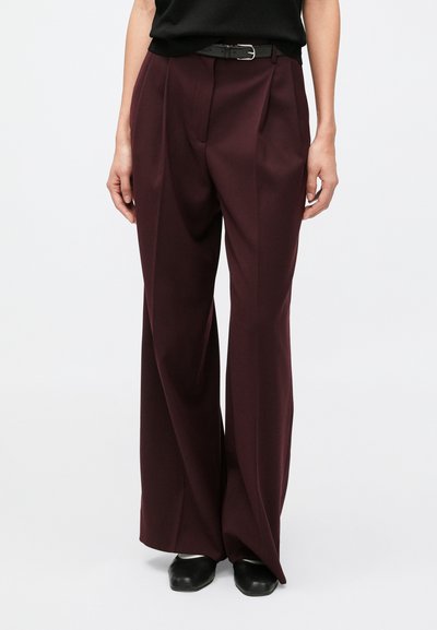Wide-leg trousers in deep burgundy fabric, featuring front pleats, tailored waistband, and a black belt. Smooth texture, formal design.