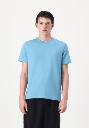 Ljusblå kortärmad t-shirt med crew neck, tillverkad av bomull, med en liten logotyp på vänster bröst och en vanlig passform.