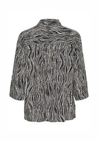Black and white blouse with three-quarter sleeves, featuring a wave pattern and a back pleat for added volume. Smooth fabric texture.
