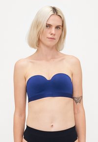 Reggiseno senza spalline di colore blu navy con una texture liscia e un logo discreto sulla fascia. Presenta un colletto a forma di cuore e un design senza cuciture per il massimo comfort.