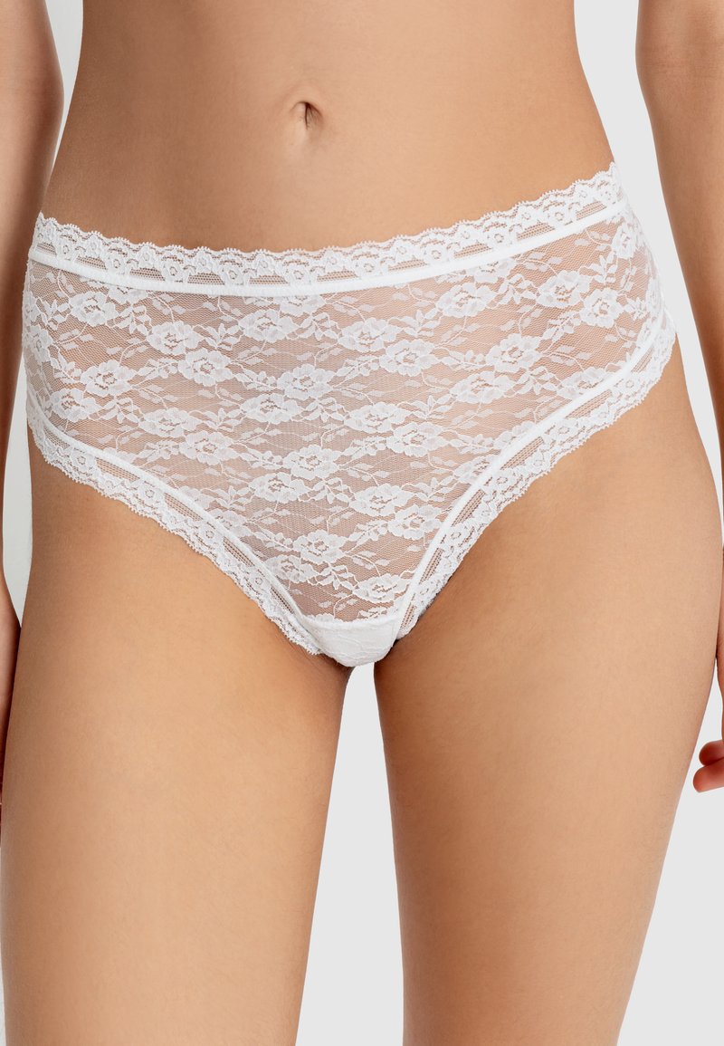 Witte kanten slipjes met bloemenpatroon, voorzien van een golvende tailleband en afwerking. Doorzichtig materiaal voegt een delicate textuur toe aan het ontwerp.