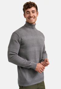 Grå genser med høy hals laget av strikket materiale med teksturerte horisontale striper; tettsittende design og ribbede mansjetter og kant.