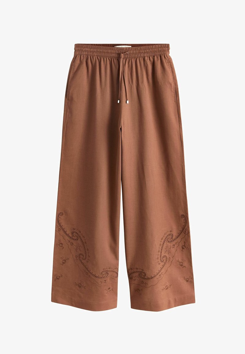 Pantalon ample marron avec ceinture élastique, cordon de serrage, poches latérales et motifs floraux brodés subtils près des ourlets inférieurs.