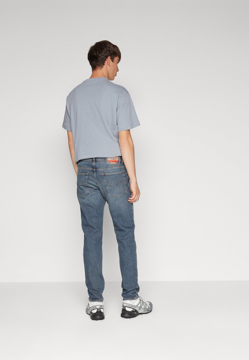 Lichtblauwe katoenen t-shirt, relaxed fit, gecombineerd met donkerblauwe denim jeans. Geweven sneakers maken de casual look compleet.