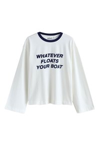 Chemise blanche à manches longues avec col bleu marine et texte bleu marine indiquant "WHATEVER FLOATS YOUR BOAT" sur le devant.