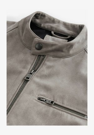 Grau Wildlederjacke mit hohem Kragen, frontalem Reißverschluss und einer Reißverschlusstasche. Glatte Textur mit silbernen Hardware-Akzenten.