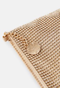 Zlatě tónovaná kabelka typu clutch s texturovaným povrchem z kovových hrotů, vybavená řetízkovým popruhem a kulatým logem s květinovým motivem.