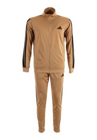 Tuta beige con strisce nere sulle maniche e sui pantaloni, giacca con zip a tutta lunghezza e colletto alto, e logo nero sul petto e sulla coscia.