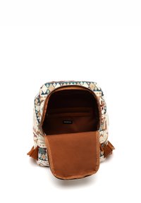 Textured backpack with a patterned fabric exterior in cream, blue, and red, featuring a brown fabric inner lining and a zippered pocket.