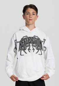 Felpa bianca con tasca frontale, caratterizzata da una grafica testuale nera che recita "RIFLESSIONE" con accenti astratti. Tessuto morbido e stile a pullover.