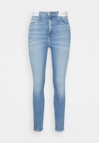 Světle modré skinny džíny s vysokým pasem, předními kapsami, zapínáním na knoflík a zip, a bílým detaily na pásku Calvin Klein.