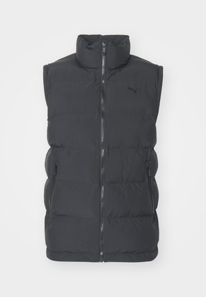 Black puffer vest made of synthetic material with high collar, front zip, and two side zippered pockets. Features a logo on the chest.