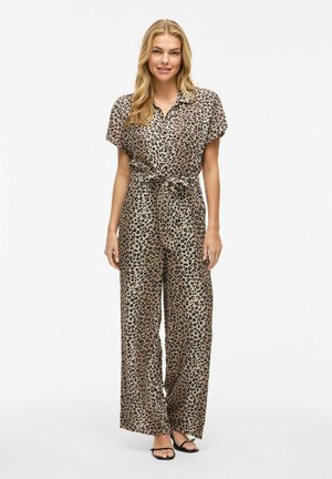 Combinaison à imprimé léopard avec des manches courtes, fermeture à boutons, taille cintrée et pantalons à jambes larges en tissu lisse dans des tons de tan et de noir.