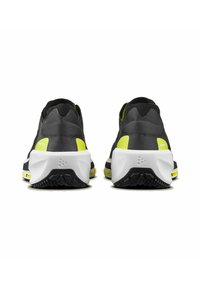 Baskets noires et grises avec des détails jaune vif. Elles présentent un uppers texturé, une semelle intermédiaire blanche rembourrée et une semelle extérieure en caoutchouc noir.