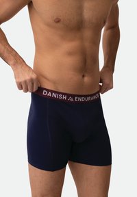Granatowe bokserki z bordowym elastycznym pasem z napisem "DANISH ENDURANCE" w białym kolorze. Materiał wydaje się gładki, a fason dopasowany.