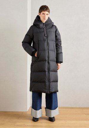Black puffer coat with a high collar and zip closure, featuring rectangular quilting, side pockets, and a long design down to mid-calf.