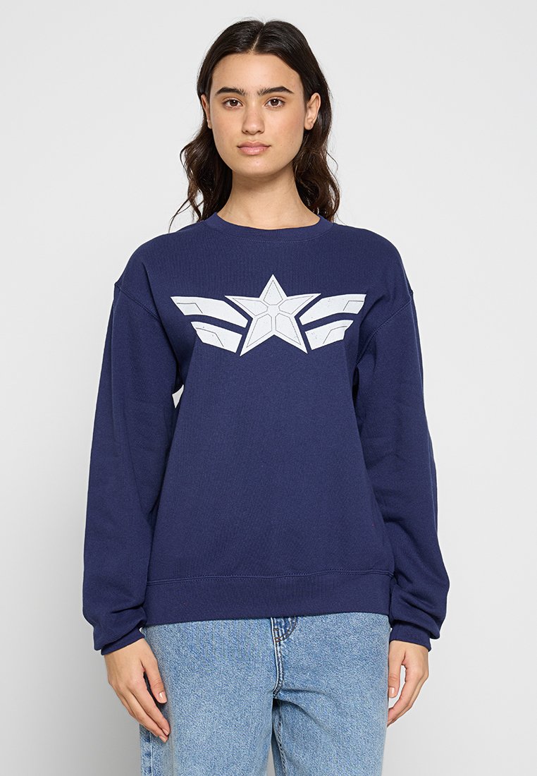 Marinblå sweatshirt med långa ärmar och rundad hals. Har en stor vit stjärngrafik med vingaccentuer på framsidan. Tillverkad av bomull.