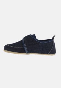 Scarpe slip-on in denim morbido di colore blu navy, con cuciture a contrasto, punta arrotondata e suola in gomma flessibile. Presentano un anello sul tallone per indossarle facilmente.