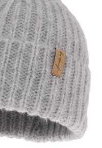 Cappello a maglia grigio con trama a coste, con etichetta in pelle color cuoio cucita sul lato, materiale morbido simile alla lana.