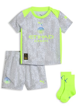 Equipación de fútbol infantil del Manchester City con camiseta y pantalones cortos grises con estampado, ribetes amarillo neón y calcetines amarillo neón con el logo azul de Puma.