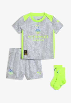 Manchester City børnefodboldkit med grå mønstret trøje og shorts, neon gul kant og neon gule strømper med blå Puma-logoer.
