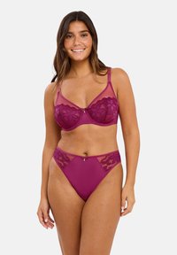 Soutien-gorge en dentelle transparente violette et culotte taille haute assortie avec des motifs floraux, une texture douce et un petit nœud central.