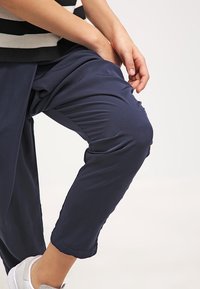 Granatowe, krótkie spodnie wykonane z miękkiego, lekkiego materiału o luźnym kroju. Posiadają boczne kieszenie oraz delikatne marszczenie w okolicy kolan.