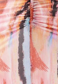 Flerfärgad mönstrad tyg som har en blandning av mjuka rosa, blå och svarta nyanser med samlad textur och en nätliknande väv.