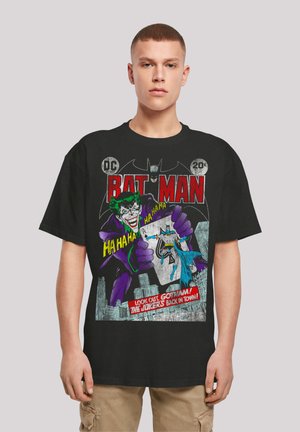 Black cotton t-shirt featuring a comic-style Batman and Joker graphic with text. Vibrant colors include purple, red, and blue. Casual fit.