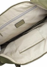 Green, zippered bag interior with beige fabric lining, featuring a zip pocket and a flat slip pocket. Textured material and smooth finish.