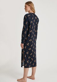 Abito da notte lungo blu navy con maniche lunghe, caratterizzato da una stampa giocosa di cervi e cuori. Il tessuto sembra morbido con una leggera lucentezza.