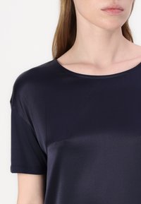T-shirt blu navy a maniche corte realizzato in tessuto morbido, con scollatura rotonda e vestibilità comoda. Leggero lucido e senza motivi o decorazioni visibili.