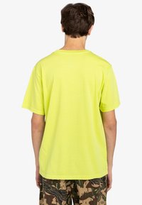 Neon yellow cotton t-shirt with short sleeves and a crew neck. The back features a smooth texture and a simple design without patterns.