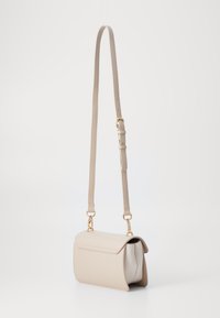 Beige kožená crossbody taška s přehnutým klopovým víkem, zlatou kováním a nastavitelným popruhem; má kontrastn�í bílé vnitřní provedení.