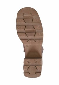 Suela de goma con una superficie texturizada de color marrón. Presenta surcos multidireccionales y patrones hexagonales para mejorar la tracción. Se indica el tamaño 37.