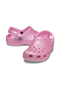 Różowe klapki crocs wykonane z lekkiego materiału, z otworami wentylacyjnymi, tylnym paskiem zapewniającym pewne dopasowanie oraz błyszczącym wykończeniem.