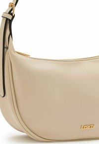 Borsa a tracolla in pelle beige con forma curva, caratterizzata da un accento del logo dorato e una tracolla nera. Texture liscia con dettagli cuciti.